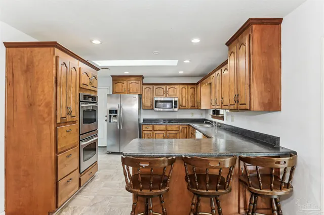 a kitchen with stainless steel appliances granite countertop a sink and a refrigerator