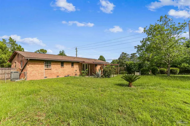 a view of a chair and table in backyard of the house