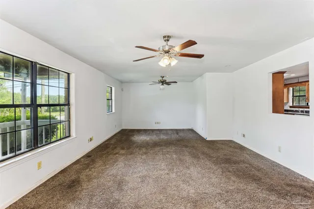 a view of a big room with chandelier fan and windows