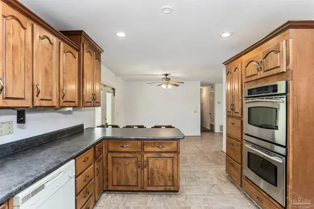 a kitchen with stainless steel appliances granite countertop a stove a sink and a microwave