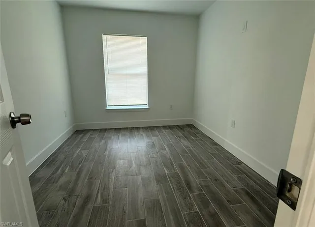 a view of a room with wooden floors and window