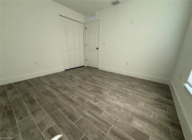 a view of a room with wooden floor and white walls