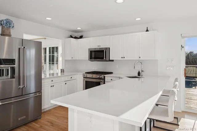 a kitchen with stainless steel appliances granite countertop a refrigerator stove microwave and sink