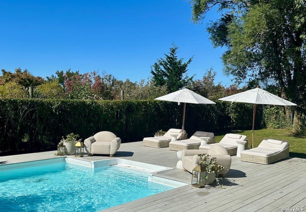 62 Sea Farm Lane Bridgehampton, NY 11932 - Photo 7 of 25 a view of a patio with a dining table and chairs under an umbrella