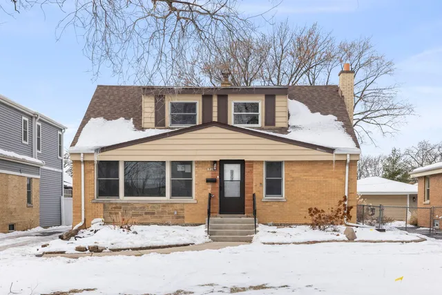 a front view of a house with a yard covered in snow
