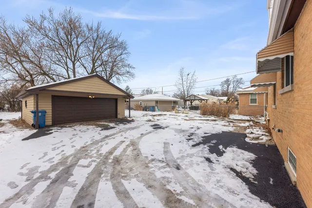 a front view of a house with a yard covered in snow