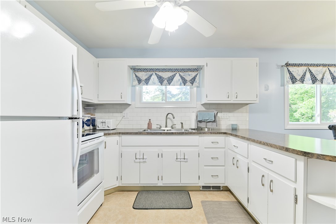 2725 Rockefeller Road Willoughby Hills, OH 44092 - Photo 5 of 21 Kitchen with sink, white appliances, light tile floors, and tasteful backsplash