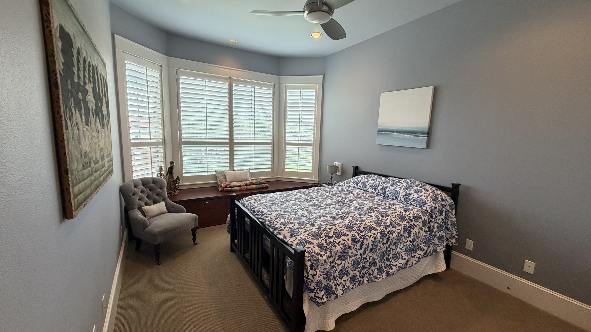 816 Stonewall Ridge Lane Austin, TX 78746 - Photo 29 of 32 A well-lit first floor bedroom features a bay window with a built-in seat, perfect for quiet contemplation. Full bath with shower just outside the room.