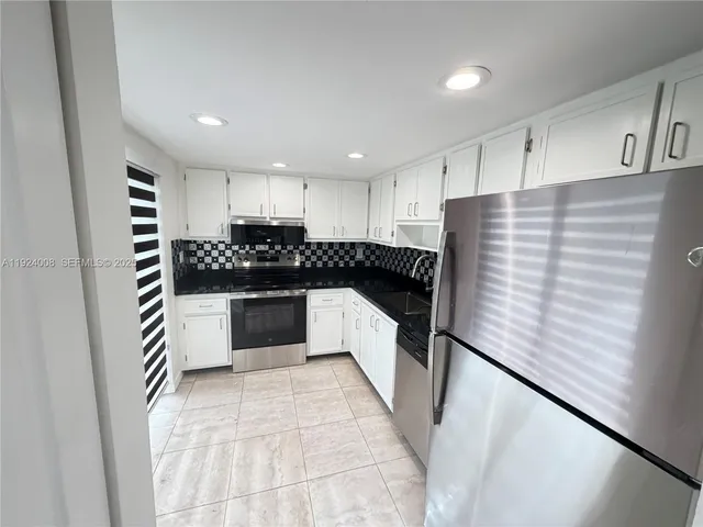 a kitchen with a sink and white cabinets