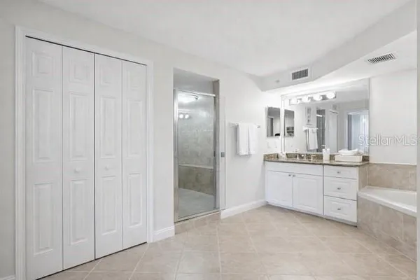 a large bathroom with a granite countertop sink mirror and a bathtub