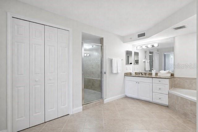 420 Harding Avenue, Unit 301 Cocoa Beach, FL 32931 - Photo 12 of 57 a large bathroom with a granite countertop sink mirror and a bathtub