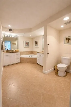 a large white kitchen with a white countertops and a fireplace