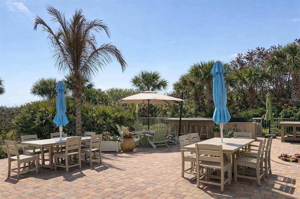 420 Harding Avenue, Unit 301 Cocoa Beach, FL 32931 - Photo 33 of 57 a view of a patio with table and chairs potted plants and palm tree
