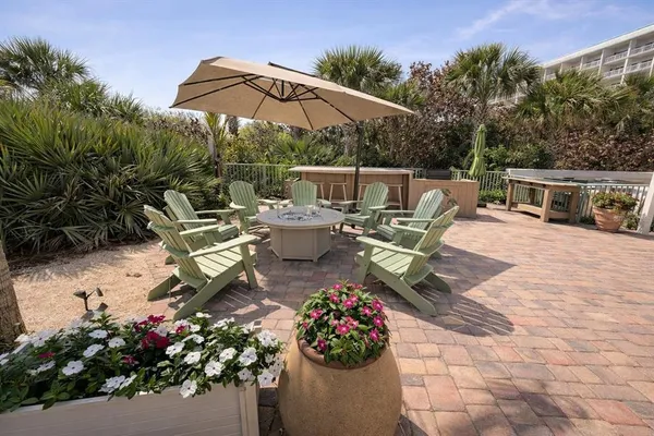 a view of a patio with a dining table and chairs under an umbrella