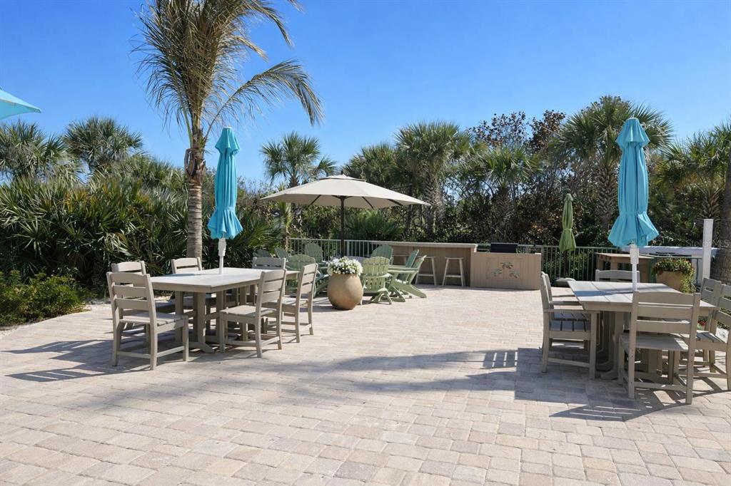 420 Harding Avenue, Unit 301 Cocoa Beach, FL 32931 - Photo 36 of 57 a view of a patio with a dining table and chairs under an umbrella
