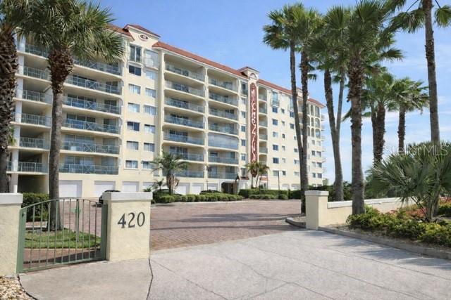 420 Harding Avenue, Unit 301 Cocoa Beach, FL 32931 - Photo 42 of 57 a front view of multi story residential apartment building with yard and sign board