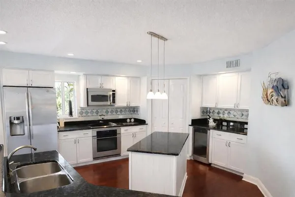 a kitchen with stainless steel appliances a refrigerator stove and sink