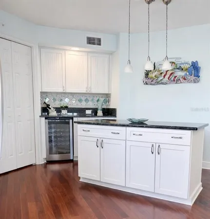 a kitchen with granite countertop white cabinets and white appliances