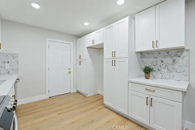a kitchen with granite countertop a stove top oven a sink a counter space and cabinets