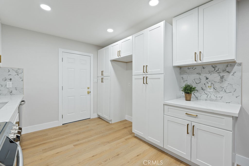911 Keith Street Barstow, CA 92311 - Photo 12 of 40 a view of a kitchen with white cabinets and wooden floor