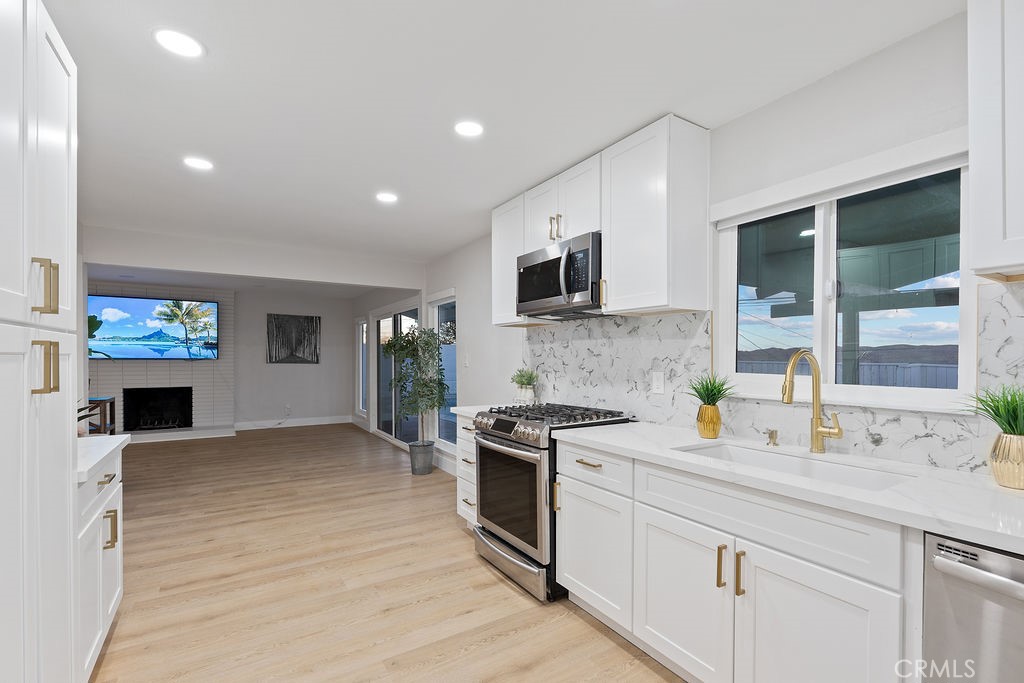 911 Keith Street Barstow, CA 92311 - Photo 13 of 40 a kitchen with granite countertop a stove top oven a sink a counter space and cabinets