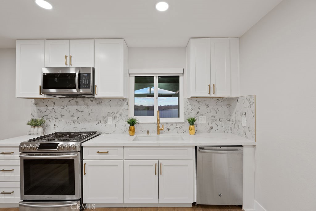911 Keith Street Barstow, CA 92311 - Photo 14 of 40 a kitchen with stainless steel appliances a stove microwave and cabinets