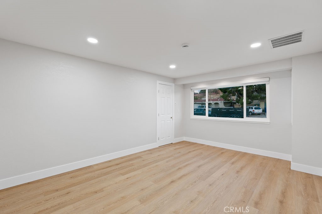 911 Keith Street Barstow, CA 92311 - Photo 19 of 40 a view of an empty room with wooden floor and a window