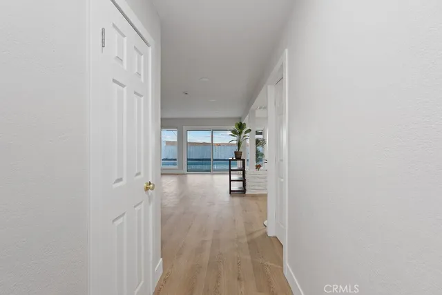 a view of empty room with wooden floor and floor to ceiling window