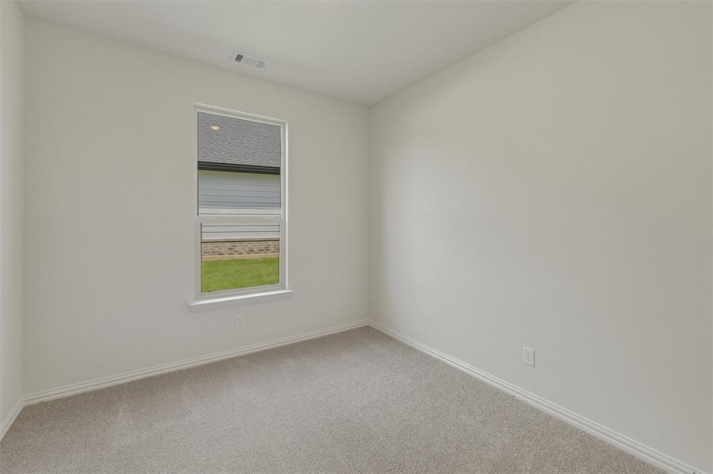 1217 Colca Drive Springtown, TX 76082 - Photo 12 of 25 Neutral tone walls with white trim and grey carpeting