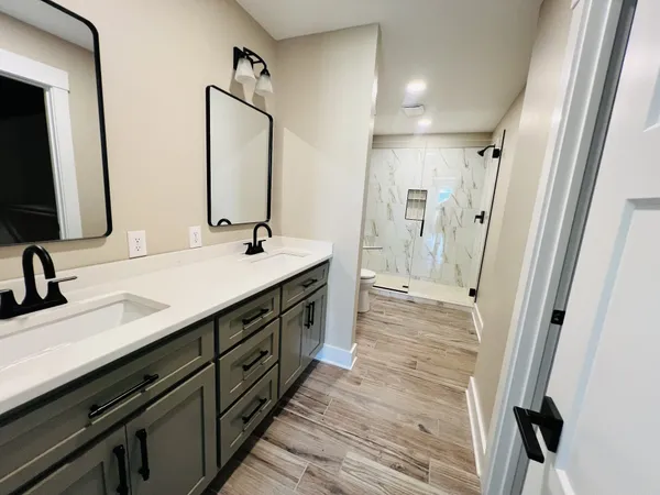 a bathroom with double vanity and a mirror