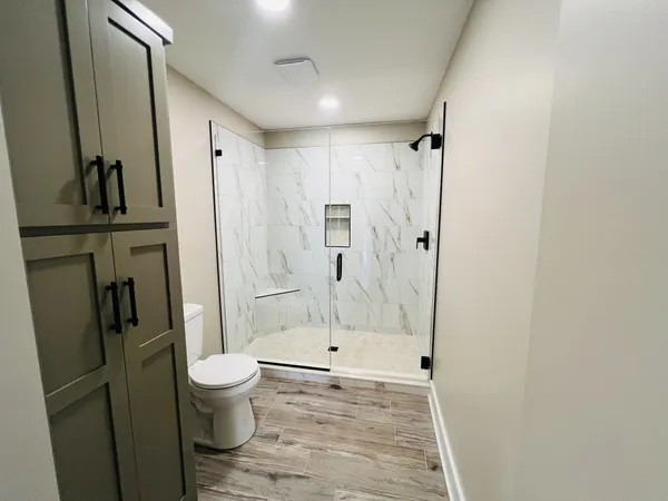 a bathroom with a toilet a sink and shower