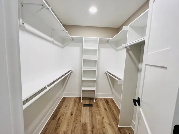a view of walk in closet with wooden floor