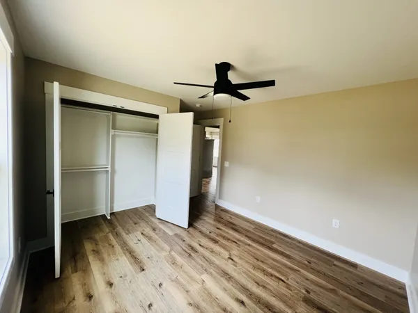 a view of empty room with wooden floor