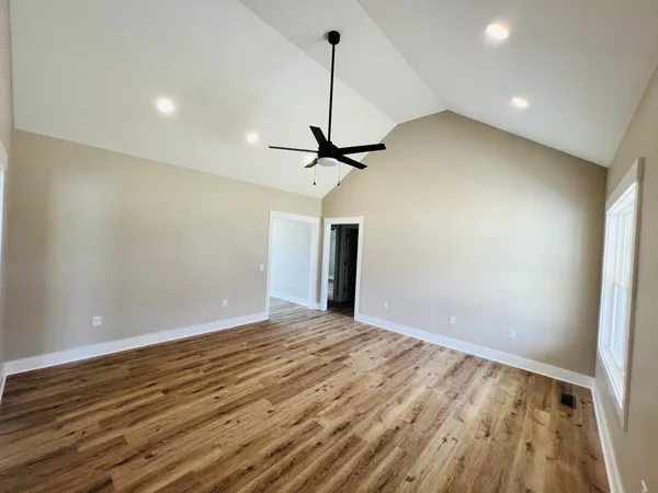 a view of a room with a ceiling fan and wooden floor