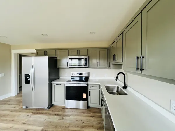 a kitchen with stainless steel appliances kitchen island a refrigerator and a sink