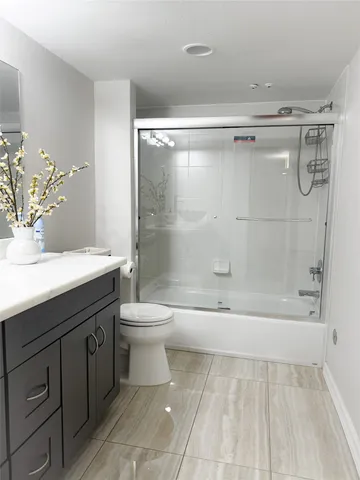 a bathroom with a bathtub shower sink vanity and toilet