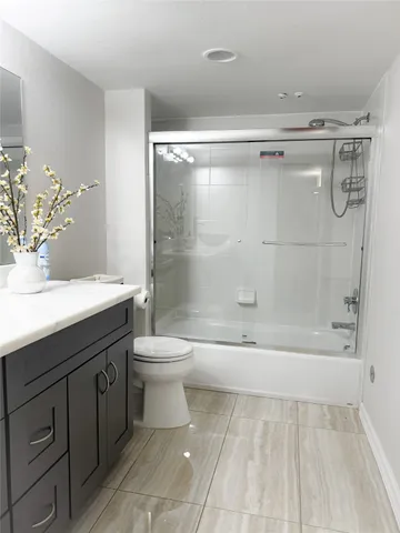 a bathroom with a bathtub shower sink vanity and toilet