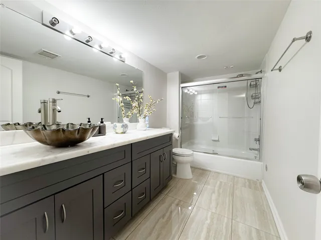 a bathroom with a double vanity sink a toilet and a bathtub