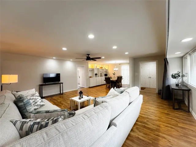 a living room with furniture and a wooden floor