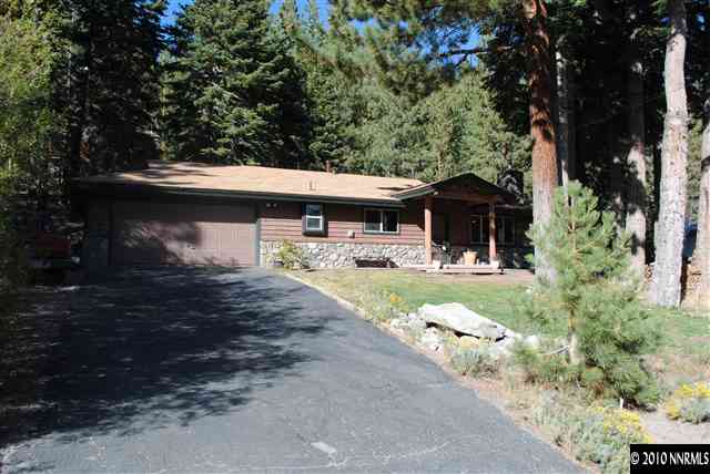355 Andria Drive Stateline, NV 89449 - Photo 2 of 13 a view of patio with table and chairs under an umbrella with large trees