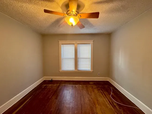an empty room with a window and wooden floor