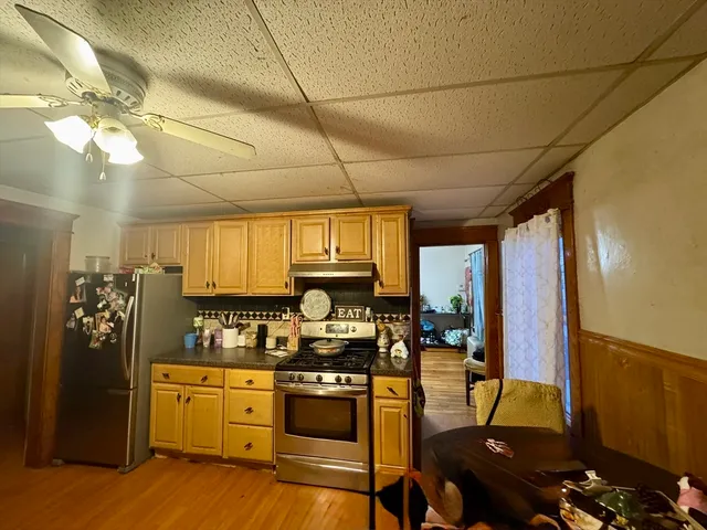 a living room with furniture a chandelier and wooden floor