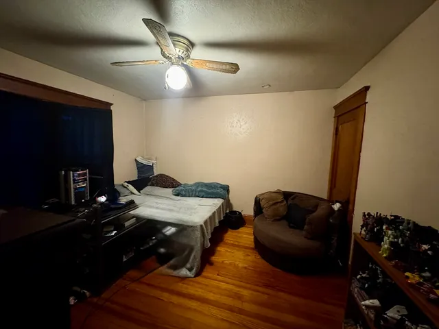 a view of a livingroom with furniture hardwood floor and a ceiling fan
