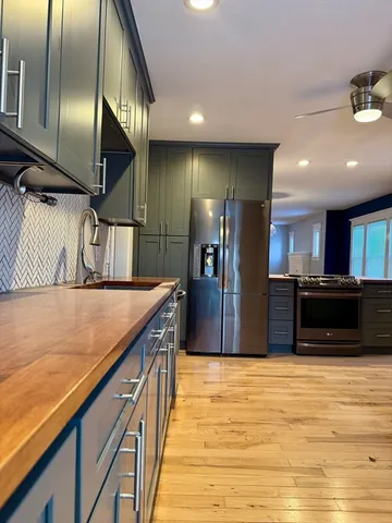 a kitchen with kitchen island granite countertop a sink and refrigerator