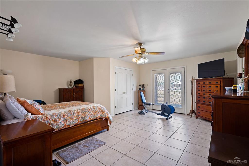 501 South Greene Road Mission, TX 78572 - Photo 13 of 28 a bedroom with a bed and gym equipment
