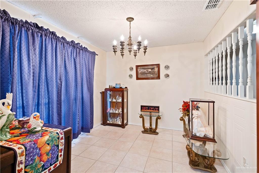 501 South Greene Road Mission, TX 78572 - Photo 3 of 28 a bedroom with furniture and a chandelier