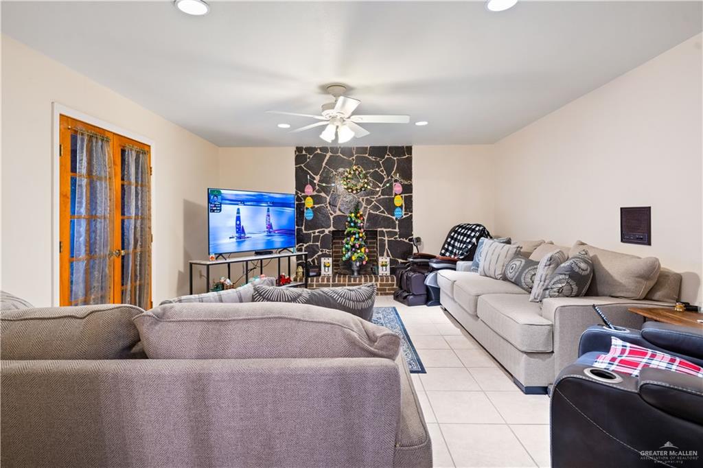 501 South Greene Road Mission, TX 78572 - Photo 4 of 28 a living room with furniture a chandelier and a flat screen tv