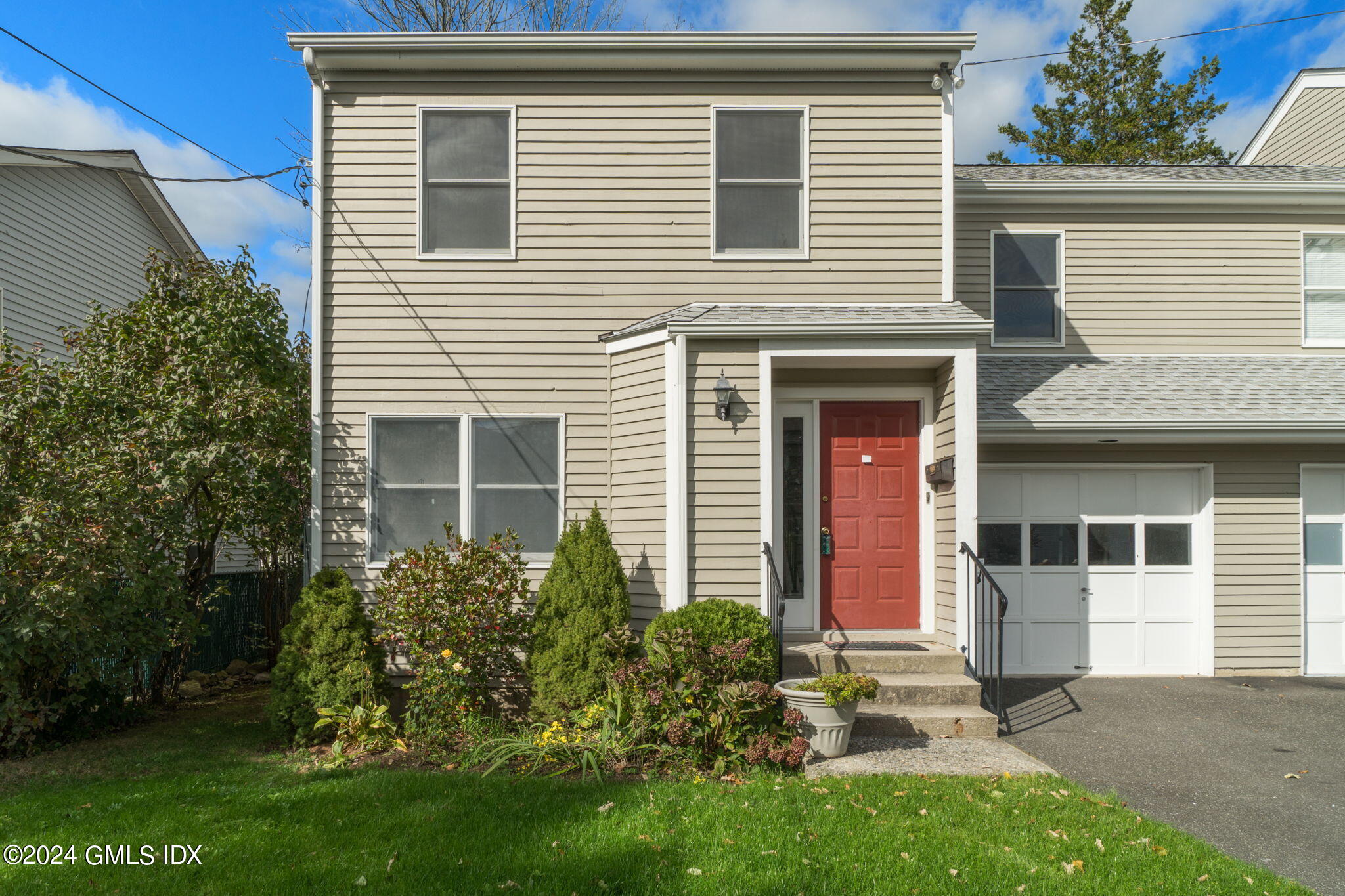 10 Tulip Street, Unit A Cos Cob, CT 06807 - Photo 1 of 27 a front view of a house with a garden and plants