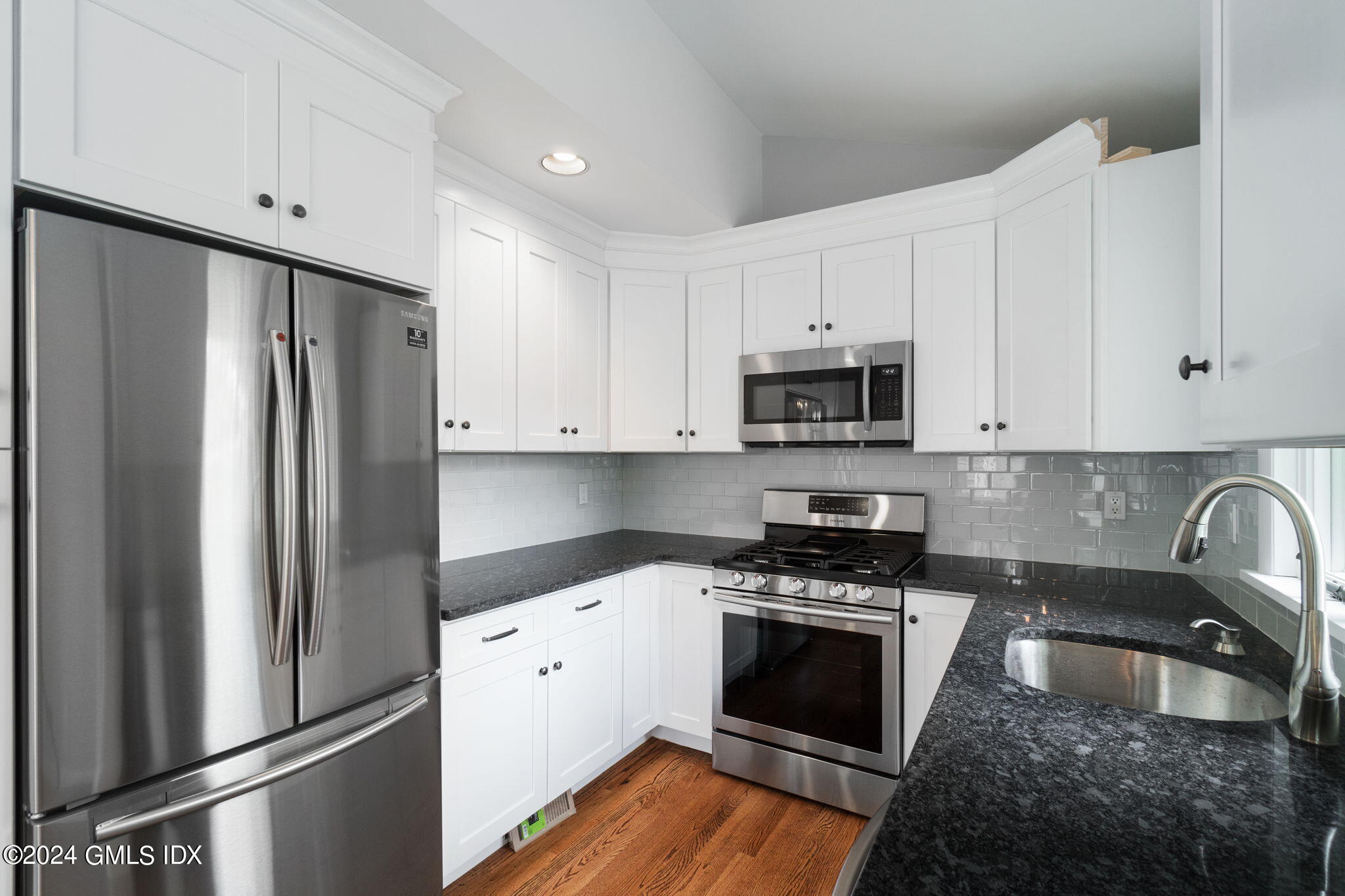10 Tulip Street, Unit A Cos Cob, CT 06807 - Photo 2 of 27 a kitchen with granite countertop white cabinets and stainless steel appliances