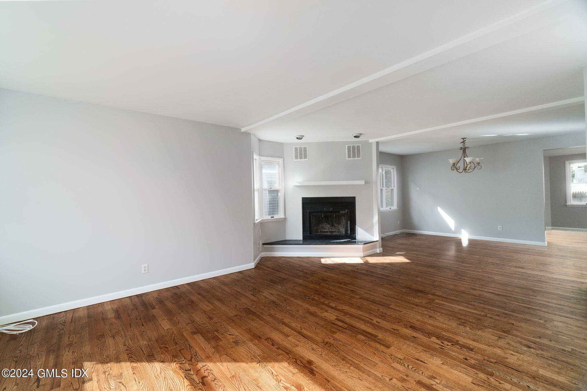 10 Tulip Street, Unit A Cos Cob, CT 06807 - Photo 5 of 27 a view of empty room with wooden floor and fireplace